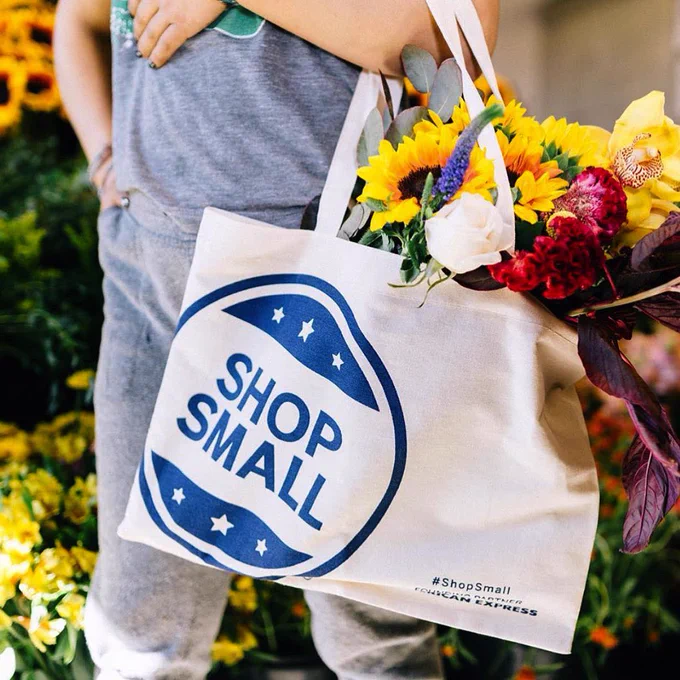 Person holding a Shop Small tote bag at the Midtown Farmers Market.