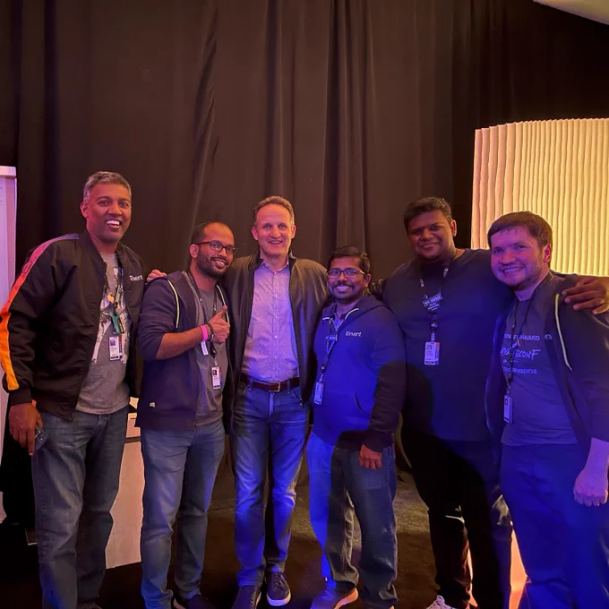 Group of men, all wearing jeans and casual jackets. All smiling at camera
