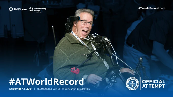 A man in a wheelchair smilng with the text #ATWorldRecord