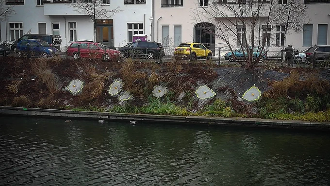 Spots on a rock wall are made of concrete. These spots are outlined by a yellow neon colored spray line that separates them from the rock wall.