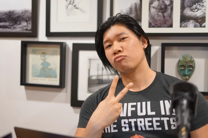 Picture at the podcast studio. I'm making a really silly duck face and throwing up a ✌️ sign. In a black t-shirt that reads "Lawful in the streets", rest is cut off.