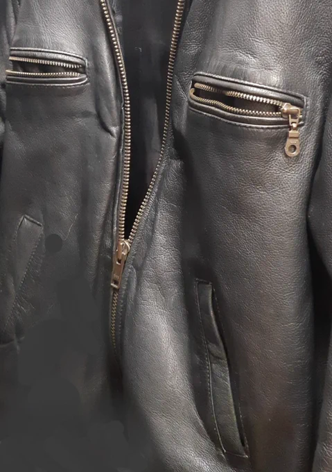 A close-up of a leather jacket showing three pockets