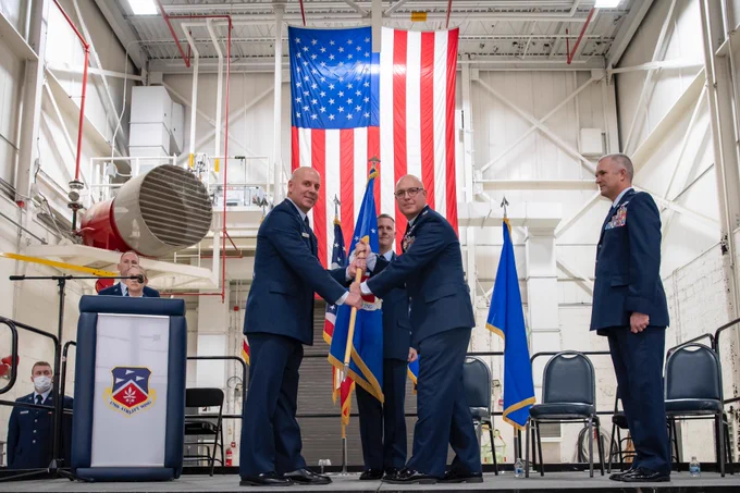 Brig. Gen. Gary McCue, director of the joint staff for the Ohio National Guard, takes the ceremonial guidon as presiding officer from Col. Todd K. Thomas, 179th Airlift Wing outgoing commander, as Col. Darren E. Hamilton (right), incoming commander, prepares to step in during the 179th Airlift Wing change of command ceremony at Mansfield Lahm ANGB, Ohio, Dec. 3, 2021. The passing of a unit’s guidon symbolizes a transfer of command. Col. Todd K. Thomas is retiring as Col. Darren E. Hamilton takes command. (U.S. Air National Guard photo by Master Sgt. Joe Harwood)