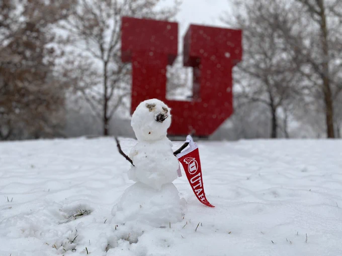 Photo of a mini snowman with a mini Utah pennant with the Block U background