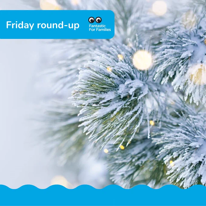 
A branch of a conifer tree covered in snow, with yellow-ish white fairylights
