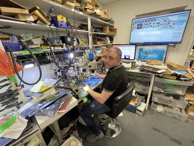 Electrical engineer Haider Issa sits at his desk, with dozens of wires, computer parts and tools in front of him. He's using a microscope to repair and recover data from the soldered-together innards of a MacBook laptop.