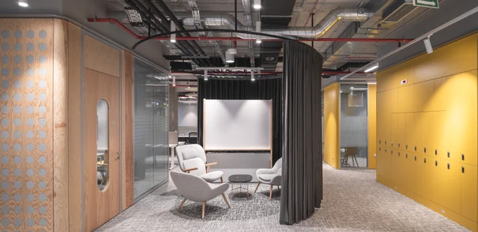 Open workspace area at Microsoft Bucharest with a separation curtain to an open meeting space. 
