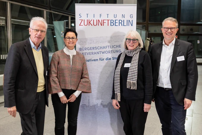 Volker Hasseer, Annett Jura, Susanne Stumpenhusen und Philipp Bouteiller stehen vor einem Banner der Stiftung Zukunft Berlin