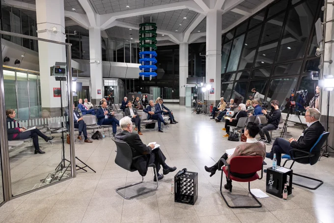 Menschen sitzen in einer ehem. Abflughalle am Flughafen Tegel bei der Veranstaltung