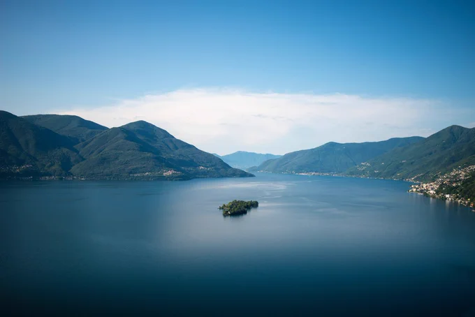 View of a Swiss lake surrounded by low forested mountains.