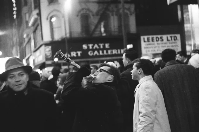 A man blows a party horn celebrating New Year's Eve at North State Street and West Randolph Street, Chicago, December 31, 1961. ST-15002870-0007, Chicago Sun-Times collection, CHM