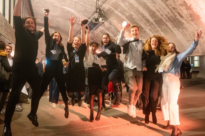 Tech4Germany und Work4Germany Fellowship-Team springend bei der Abschlussveranstaltung im Funkhaus im November
