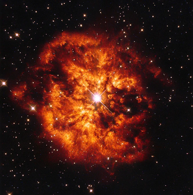 The star WR 124 lights up a brilliant, tangerine-colored nebula in this Hubble image. WR 124 is ejecting gas outward at speeds over 90,000 miles per hour into the surrounding nebula.
