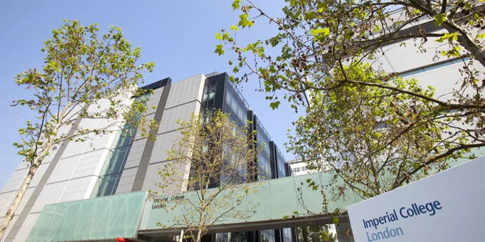 Photograph of a grey and white building (the ICTEM Building) at Imperial's Hammersmith Campus, shown on a clear day among green trees. The Imperial College logo is displayed on a sign in the foreground.