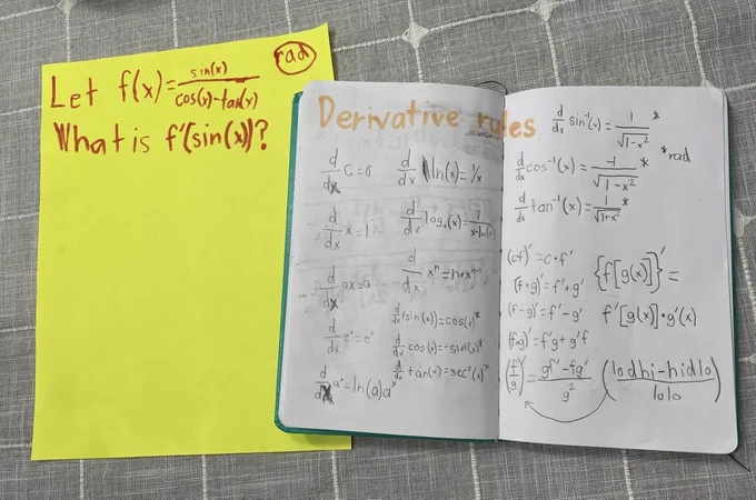 The same piece of yellow paper and formula as described in the first photo.  
The notebook is now open to a two page spread of child-written “Derivative rules”