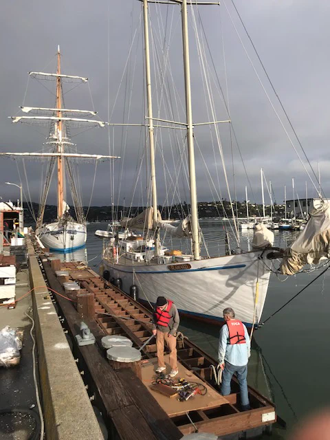 Long time carpentry Volunteers Jon Allen, aka "Rebel" and Bill Bryan, attaching cleats and the rub rail to the new dock.