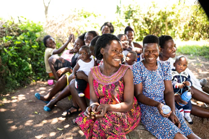Group of young women sat together smiling.