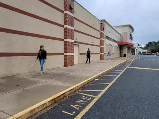 O&M students practicing white cane skills outside the mall wall