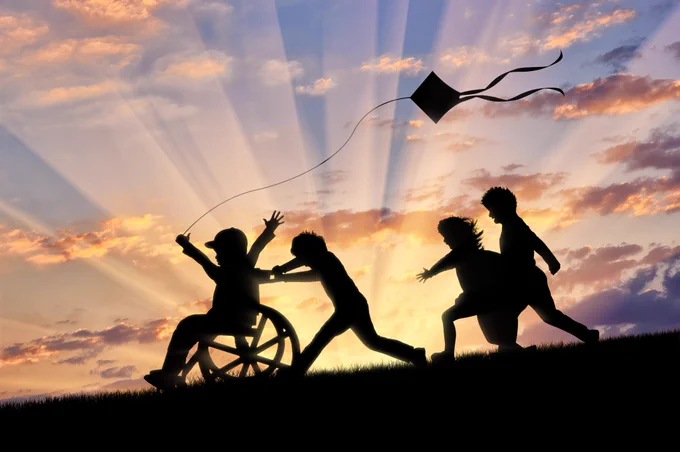 children playing in sunlight with one child in a wheelchair
