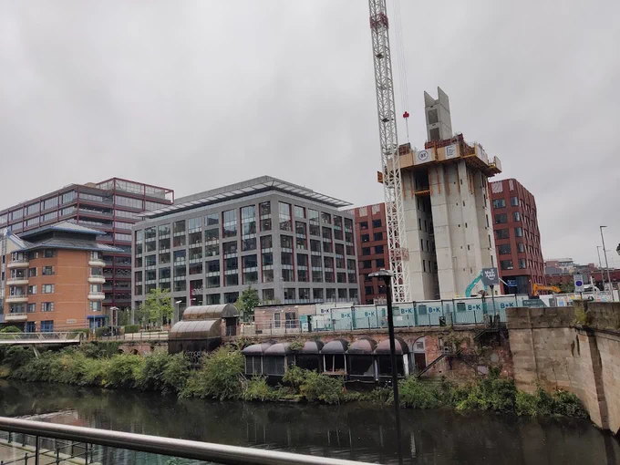 A view of part of the River Irwell near the derelict Mark Addy pub. New buildings are going up in the background
