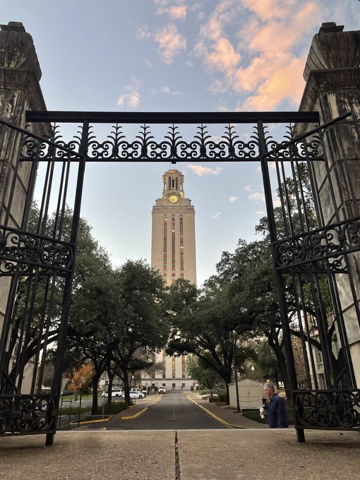UT Tower seen through a gate on campus in the early morning.