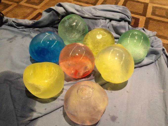 Eight head-sized balls of solid ice colored blue, yellow, green, red