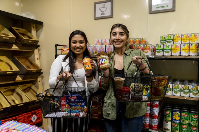 Two students posing with pantry items at Poly Pantry