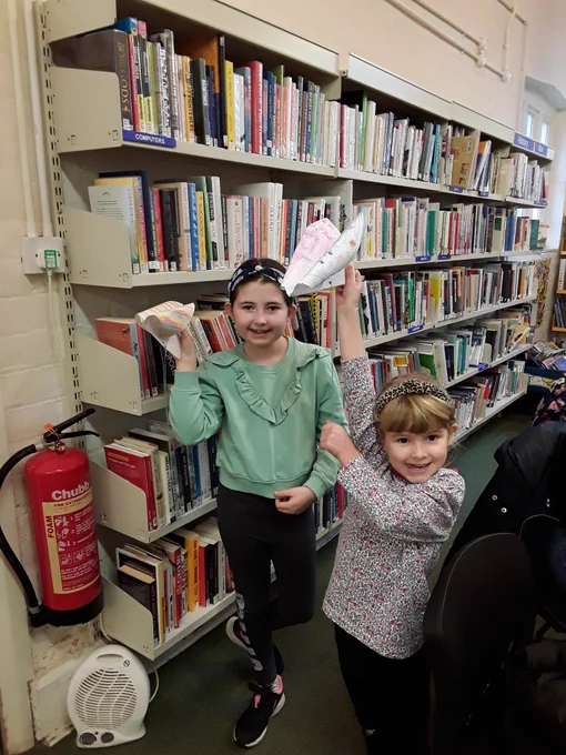 Two children show off their paper birds
