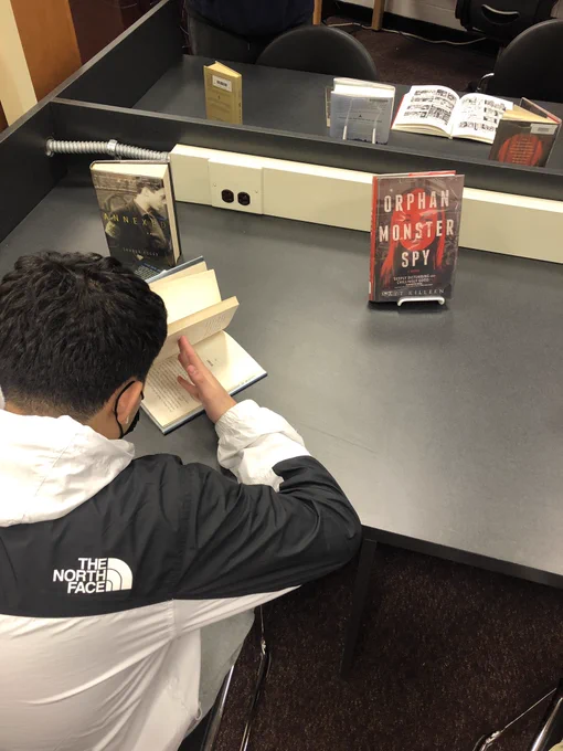 Students browse fiction books about the Holocaust