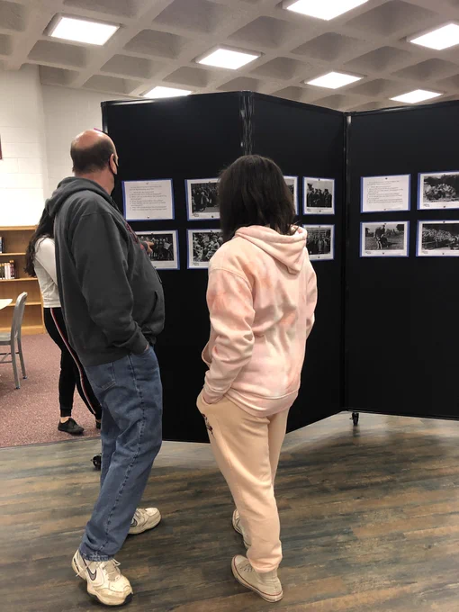 Students and instructors look at images from Auschwitz camp