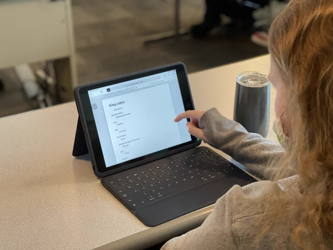 Intern is scrolling on her iPad.  An article on the screen is using a simplified via dual layout through Reader view