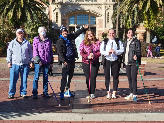 Dr. Perry and 5 O&M students pose in front of the Westcott Building at FSU