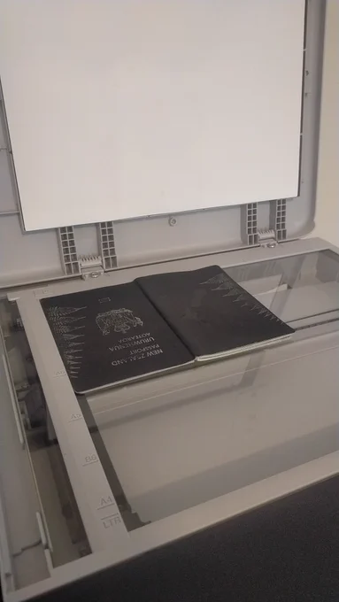 photo of a passport sitting face down in a printer scanner