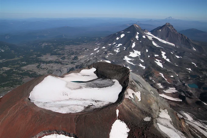 South, Middle, and North Sister volcanoes with some snow viewed aerially from the south, Three Sisters Oregon.