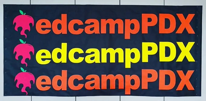 edcampPDX banner that says edcampPDX three times with the edcamp apple logo in orange and yellow letters on a black background