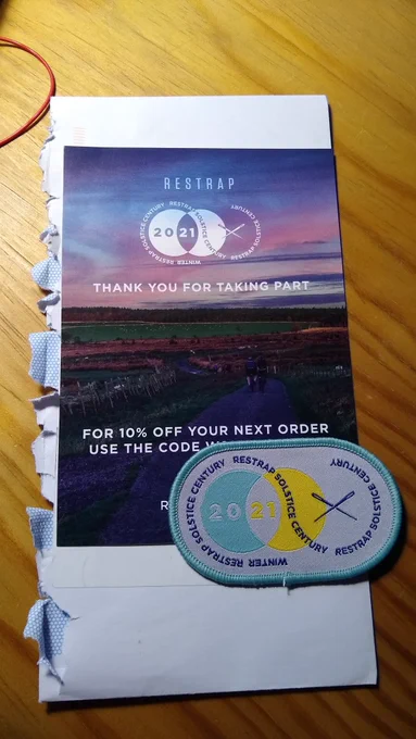The restrap Solstice Century Challenge badge and a promo card from restrap