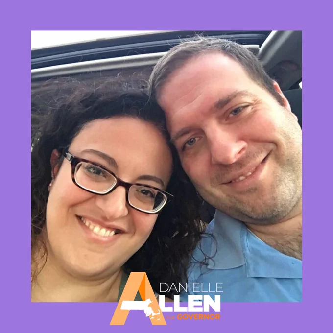 This photo shows Zeina and her husband Jason's faces taking a smiling selfie together. Zeina wears glasses and a green shirt and Jason wears a light blue shirt. There is a medium purple border and Danielle Allen's orange and white logo appears at the bottom of the photo.