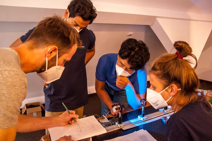 Fred showing working with students to build wide field microscope from thorlabs parts at the start of the optics module.