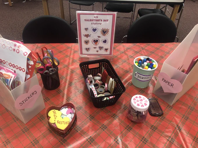 DIY Valentines Station with Valentines themed stickers, ribbons, stamps, tapes, and paper