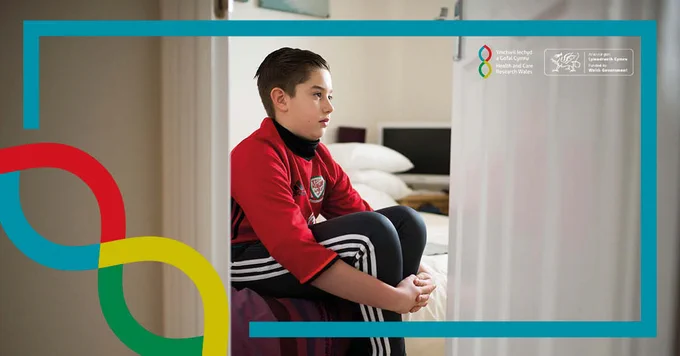 Boy sitting alone in bedroom