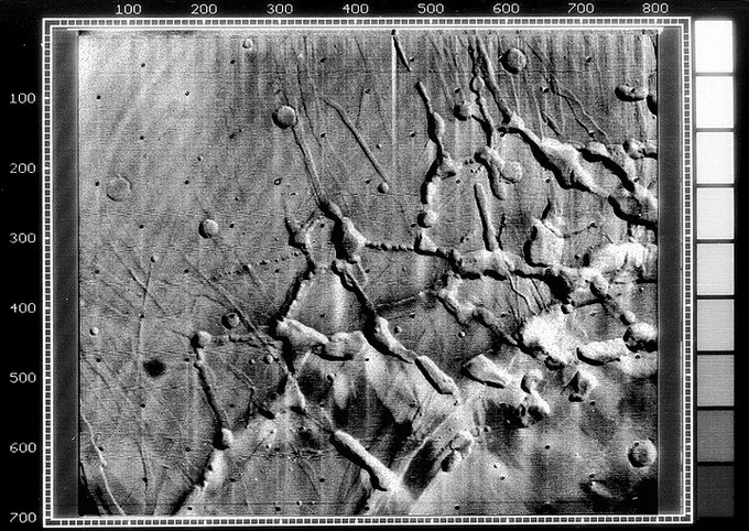 black and white view of intersecting canyons on Mars, seen from space