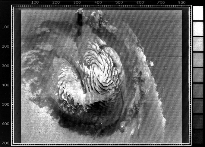 black-and-white view of swirling patterns of ice at the north pole of Mars, seen from space