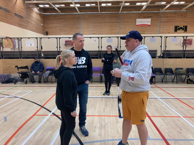 Coach explaining to participant in sports hll