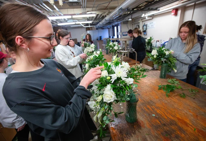 A student creates a bridal bouquet in a horticulture lab.
