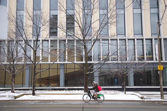 Photo shows person on bike driving past the Myhal Centre. 