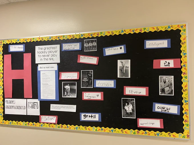 Bulletin board with photos and description of Herb Carnegie.
