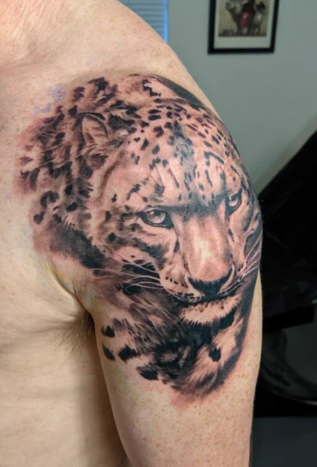 Snow leopard tattoo on left arm and shoulder