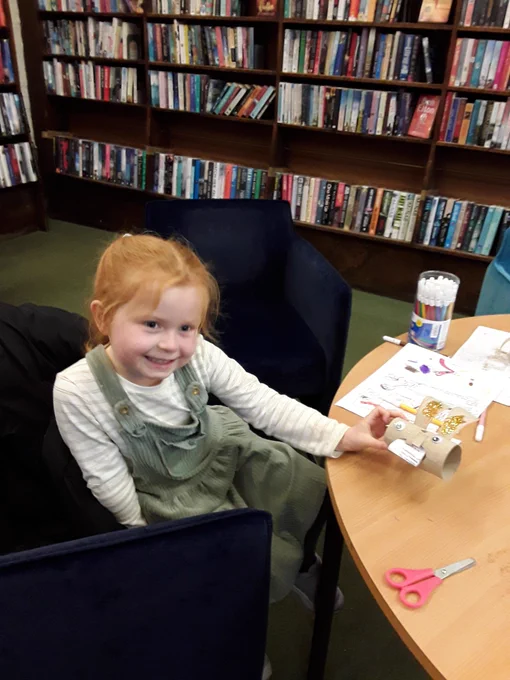Child smiles as she shows off her rabbit craft creation