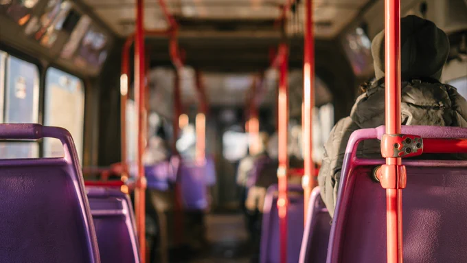 Inside of a bus seeing the backs of passengers