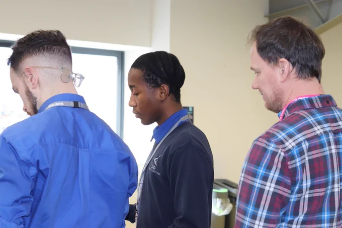 Sam from Greenhatch Group and a Derby College teacher showing a T Level student what to do.